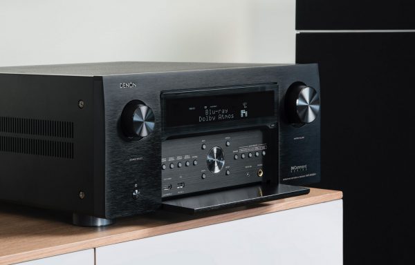 Lifestyle image of Denon AVC-X8500H AV Receiver on bench with front cover open.