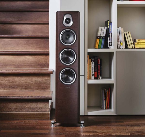 Lifestyle image of Walnut Sonus Faber Sonetto lll next to wall and bookshelf.