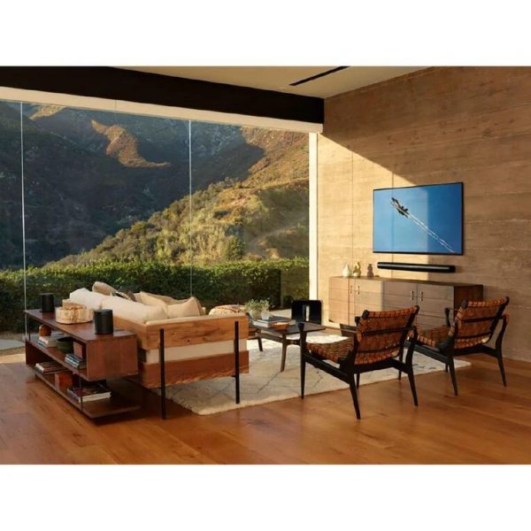 Lifestyle image of Black Sonos ARC Premium Smart Soundbar on wall in open plan living area.