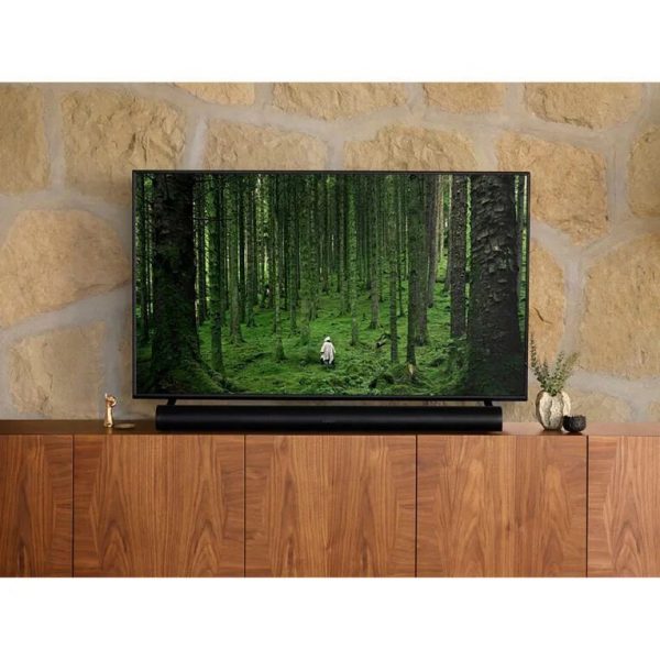 Lifestyle image of Black Sonos ARC Premium Smart Soundbar under TV on cabinet.